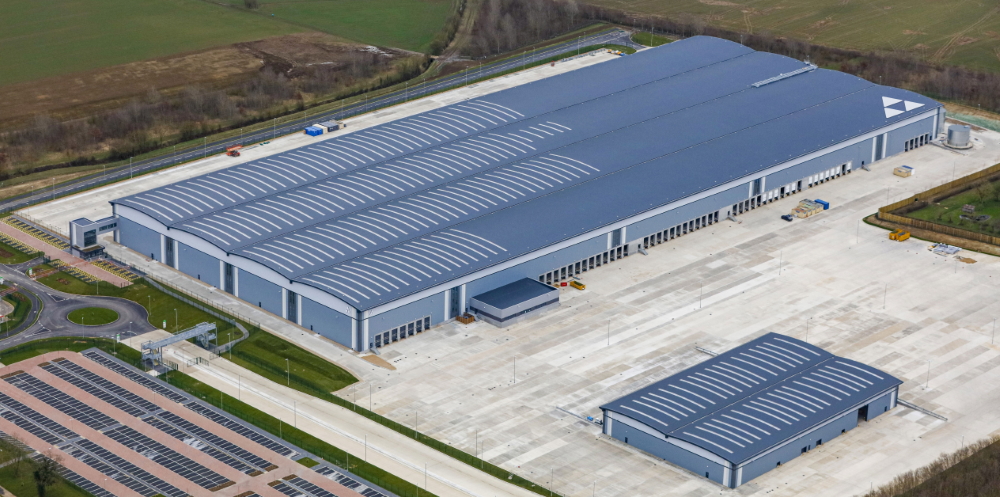 This image: a building at Symmetry Park, Biggleswade. The map: An illustrative map of main freight routes around the UK, including the East Coast Main Line, West Coast Main Line, the Felixtowe to Nuneaton Main Line, and other and future main lines. The map is also labelled with major ports and rail connections.